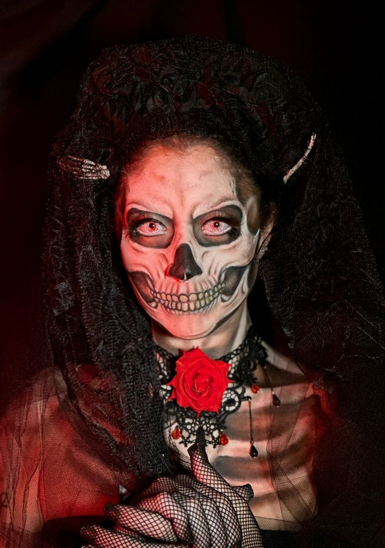 Maquiagem artística de caveira com véu e rosa vermelha